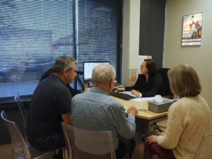 Conseiller funéraire PFI accueillant une famille en rendez-vous dans ses bureaux.