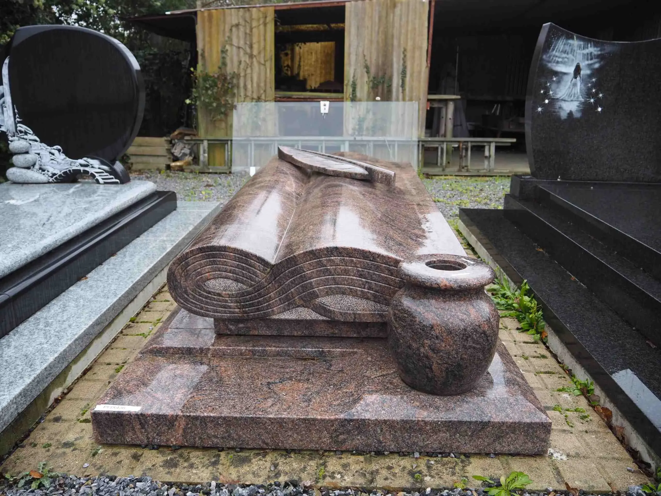 Monument funéraire original en granit sculpté en forme de livre ouvert.