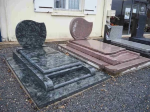 Exposition de monuments funéraires et stèles en granit rose et gris.